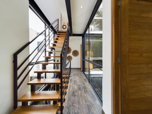 a staircase in a house with wood floors at Casa Kuaan Mani TH 1 in Tulum