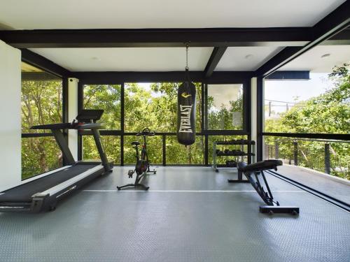 a gym with two treadmills and a punching bag at Casa Kuaan Mani TH 1 in Tulum