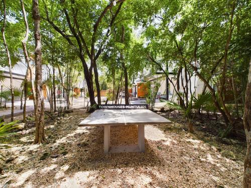 a bench in the middle of a park with trees at Casa Kuaan Mani TH 1 in Tulum