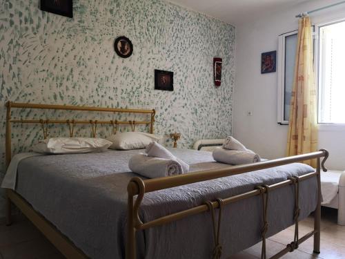 ein Schlafzimmer mit einem Bett in einem Zimmer mit Tapete in der Unterkunft Villa amygdalia in Kefalonia