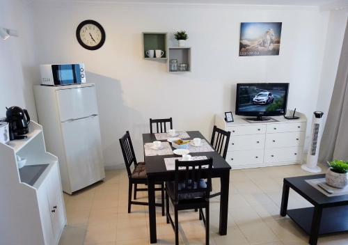 uma sala de jantar com mesa e cadeiras e uma televisão em LEON DEL SUR em San Miguel de Abona