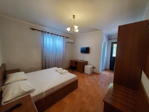 a bedroom with a bed and a desk and a television at Hotel Ceka in Durrës