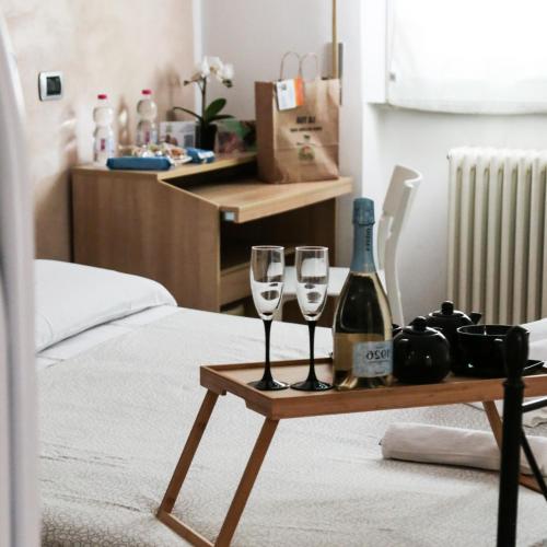 a table with two glasses and a bottle of wine at GUEST HOUSE SIMONAZZI in Reggio Emilia