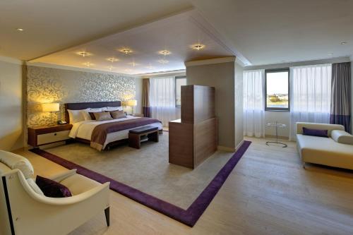a bedroom with a bed and a living room at Hilton Mainz in Mainz