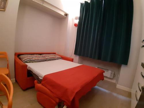 a small room with a small bed with a red blanket at Centralissimo grazioso monolocale in Turin