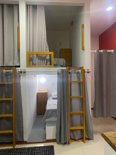 a room with a bunk bed and two ladders at Hostel Flor de Ipê in Barreirinhas