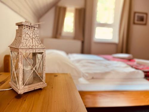 a lantern sitting on a table next to a bed at Chata U Skota in Janov nad Nisou