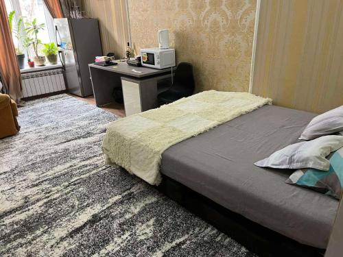 a bedroom with a bed and a desk with a computer at Golden Hotel in the Center in Chişinău