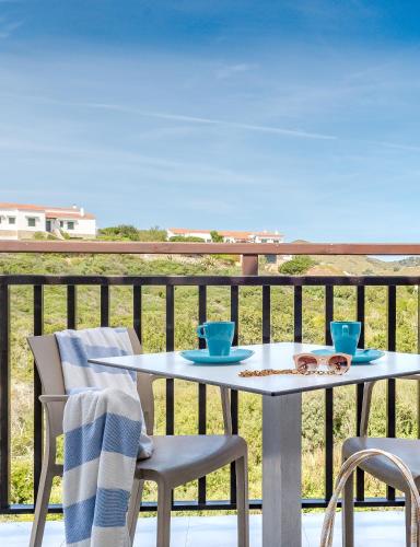 a table and chairs on a balcony with a view of the ocean at FERGUS Club Carema Splash in Fornells