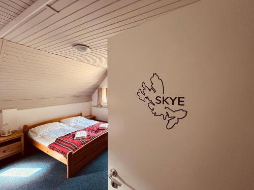 a bedroom with a bed with a sign on the wall at Chata U Skota in Janov nad Nisou
