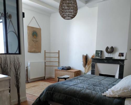 a bedroom with a bed and a fireplace in it at L' Embellie sur Lot in Sainte-Livrade-sur-Lot