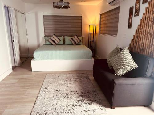 a bedroom with a bed and a couch and a chair at cozy apartment, with separate entrance in Miami