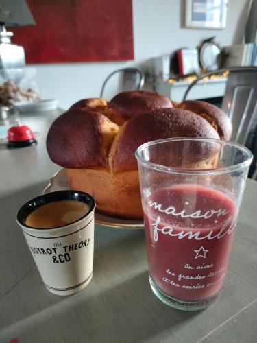 une table avec une assiette de pain et une tasse de café dans l'établissement L' Embellie sur Lot, à Sainte-Livrade-sur-Lot