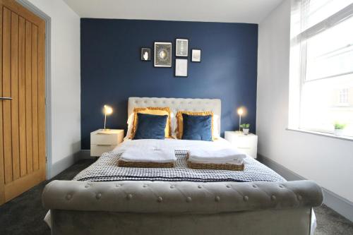 a bedroom with a large bed with blue walls at Magnificent One Bed Penthouse in Nottingham
