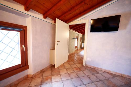 a hallway with a tv on the wall and a window at Affittacamere Residenza Del Duca in Solferino