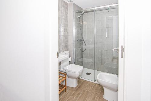 a bathroom with a toilet and a glass shower at Nautilus 3 - Elegante Apartamento para 6 con Piscina, Wifi y AC en Rota in Rota