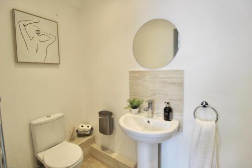 a bathroom with a sink and a toilet and a mirror at Magnificent One Bed Penthouse in Nottingham