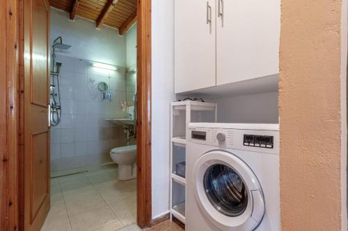 a washing machine in a bathroom with a toilet at Alice Cottage in Viros Village in Virós