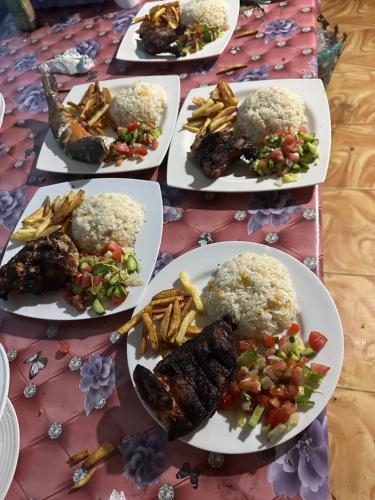 four plates of food on a table with rice and meat at Musa Camp in Nuweiba