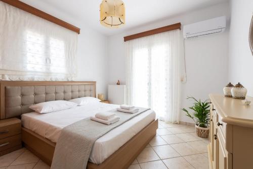 a bedroom with a bed with two towels on it at Sun and Salt 3bedroom House in Aliki