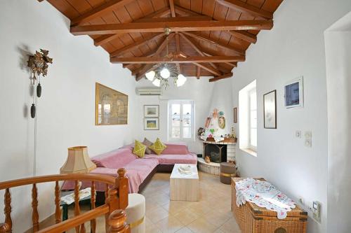 a living room with a pink couch and a fireplace at Margarita's House in Hydra