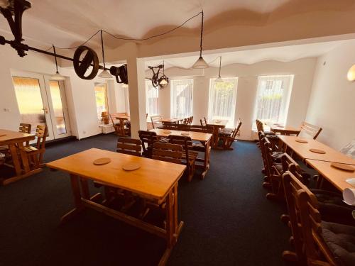 a dining room with tables and chairs and windows at Chata U Skota in Janov nad Nisou