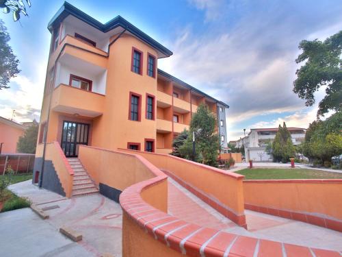 um edifício laranja com uma escada em frente em Hotel Viteama em Sellia Marina