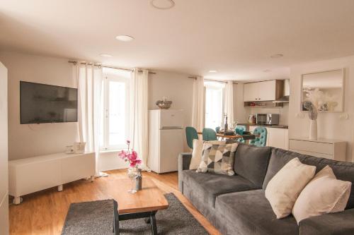 een woonkamer met een bank en een tafel bij ApartHouse Porto in Piran