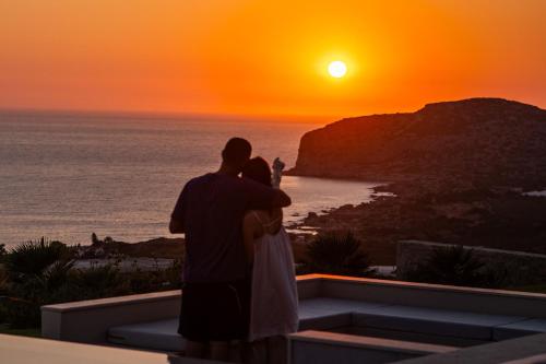 a man and a woman looking at the sunset at Cielo e Mare Villas in Falasarna