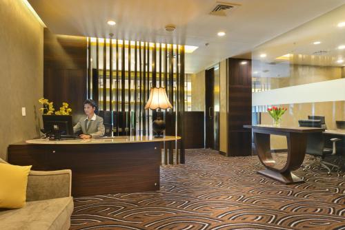 a woman sitting at a desk in a hotel lobby at Crowne Plaza Ahmedabad City Centre, an IHG Hotel in Ahmedabad