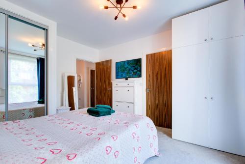 a white bedroom with a bed and a large window at Pass the Keys Cosy Apartment in the heart of Chelmsford in Chelmsford
