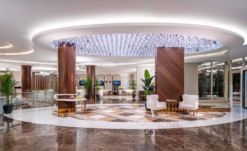 een lobby van een hotel met een blauwe kroonluchter bij Kirman Sidera Luxury & Spa in Okurcalar