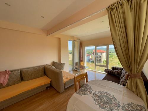 een woonkamer met een bank en een raam bij Laguna Sunset Appatments, sea and mountain view in Primorsko