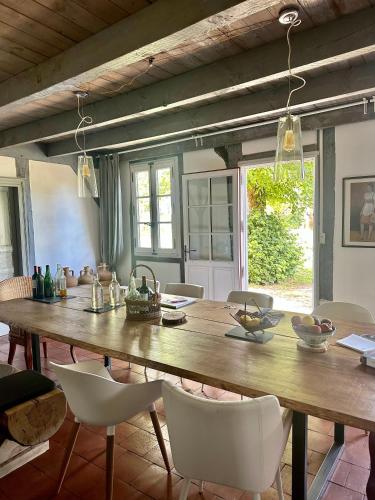 une salle à manger avec une grande table et des chaises en bois dans l'établissement Maison Magnolia, à Onesse-et-Laharie