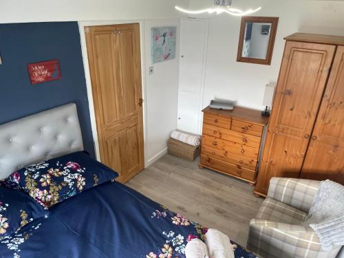 a bedroom with a bed and a dresser at Cosy Seaside Cottage in Allonby