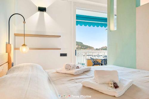 een slaapkamer met een bed met handdoeken erop bij Riflessi di Mare, TerreMarine in Portovenere