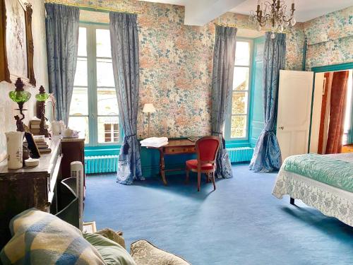 a bedroom with a desk and a bed and windows at L'Hotel de Hercé Chambre d'Hote in Mayenne