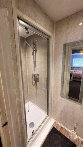 a bathroom with a shower with a glass door at 4 Bedroom 4 En Suite House Close to A5 & Whipsnade in Luton