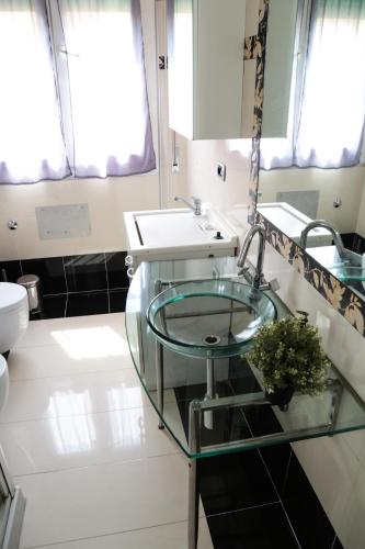a bathroom with a glass sink and a mirror at GUEST HOUSE SIMONAZZI in Reggio Emilia