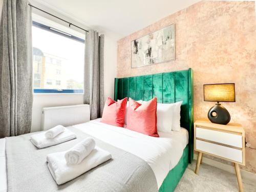 een slaapkamer met een groot bed met rode kussens bij WEEKLY OR MONTHLY STAY - Relocation & Business - 4 Guests - By Hofin Stays Short Lets & Serviced Accommodation in Londen