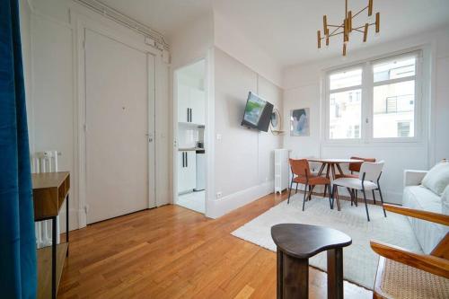 un salon blanc avec une table et des chaises dans l'établissement Appartement Arc de Triomphe - Neuilly, à Neuilly-sur-Seine