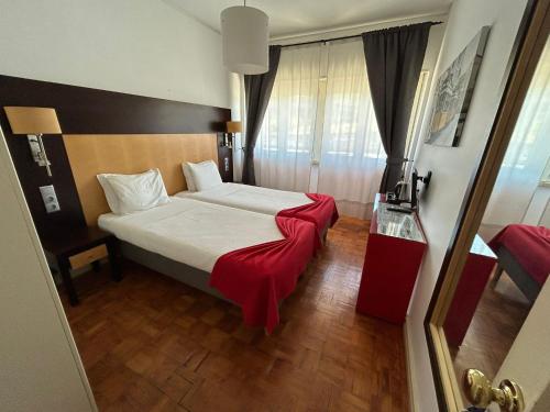 a bedroom with a bed with a red blanket on it at Discovery Apartment Benfica in Lisbon