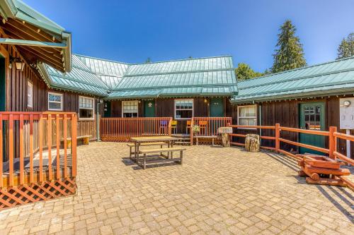 a patio with a table and benches in front of a building at The Logs Bear Cave in Snowden