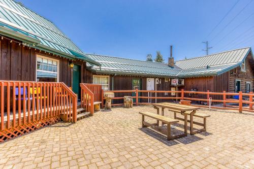 a patio with two benches in front of a building at The Logs Bear Cave in Snowden