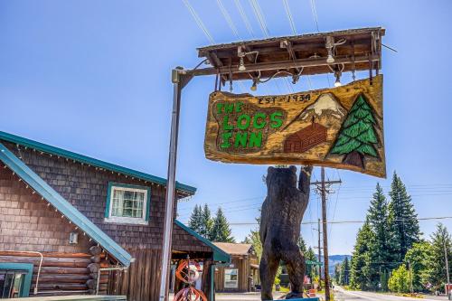 a sign for the hops inn next to a house at The Logs Bear Cave in Snowden