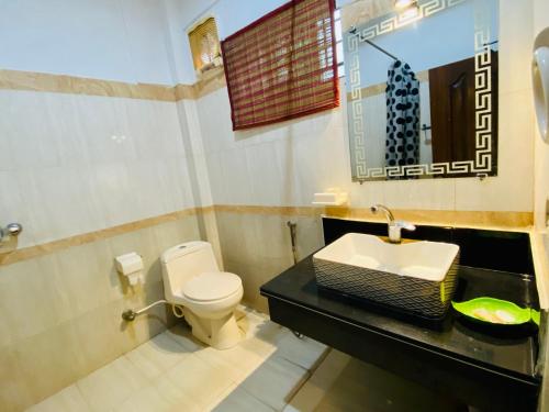 a bathroom with a toilet and a sink at Fiesta Inn Hotel & Resorts Multan in Multan