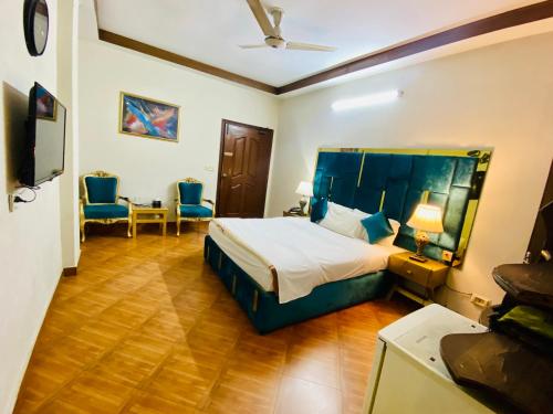 a hotel room with a bed and a table and chairs at Fiesta Inn Hotel & Resorts Multan in Multan