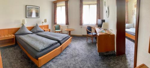 um quarto de hotel com uma cama e uma secretária e um quarto em Wohlfühlherberge Weitblick em Erlbach