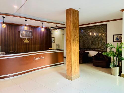 a lobby of a restaurant with a table and a bar at Fiesta Inn Hotel & Resorts Multan in Multan