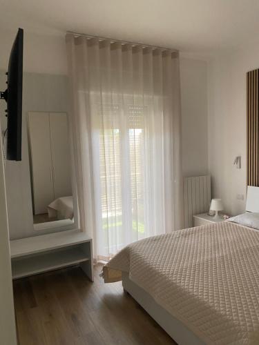 a bedroom with a bed and a large window at Dimore Capirro Charming Family House in Trani